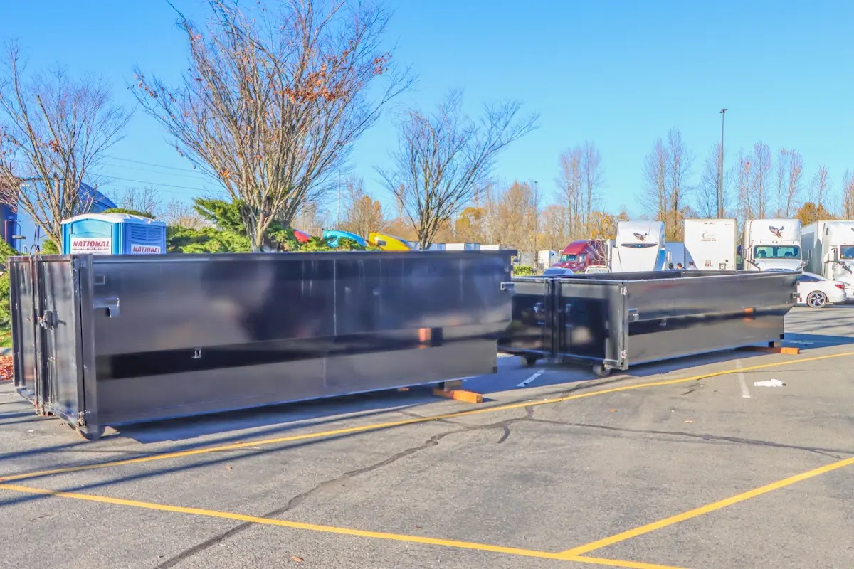 Professional dumpster rental service with roll-off container on residential driveway in Inwood